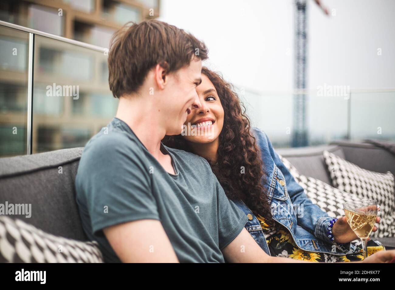 Smiling man with female partner on terrace during social gathering Stock Photo