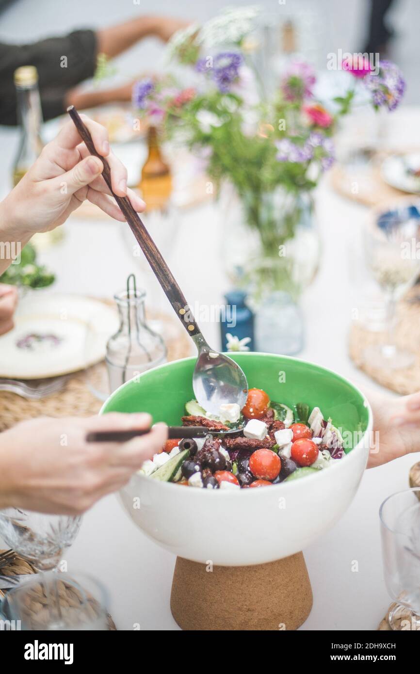 Cropped hands serving meal during social gathering on rooftop Stock Photo