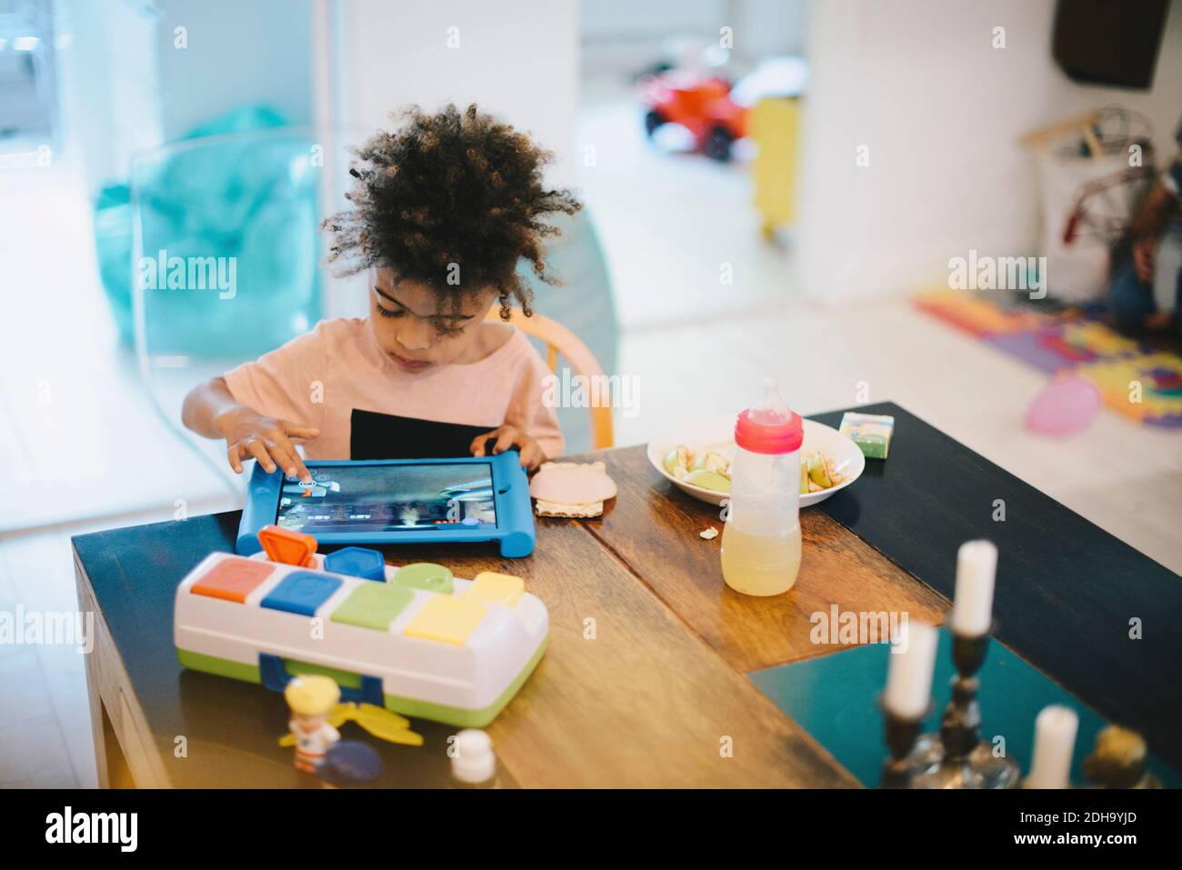 Boy using digital tablet while sitting at table Stock Photo