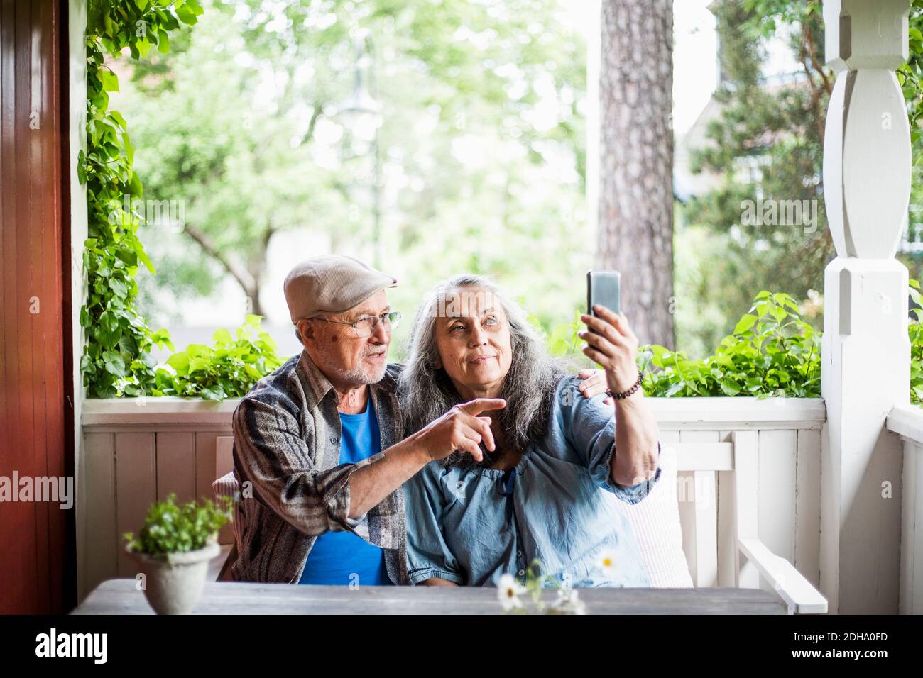 Senior couple taking selfie in porch Stock Photo
