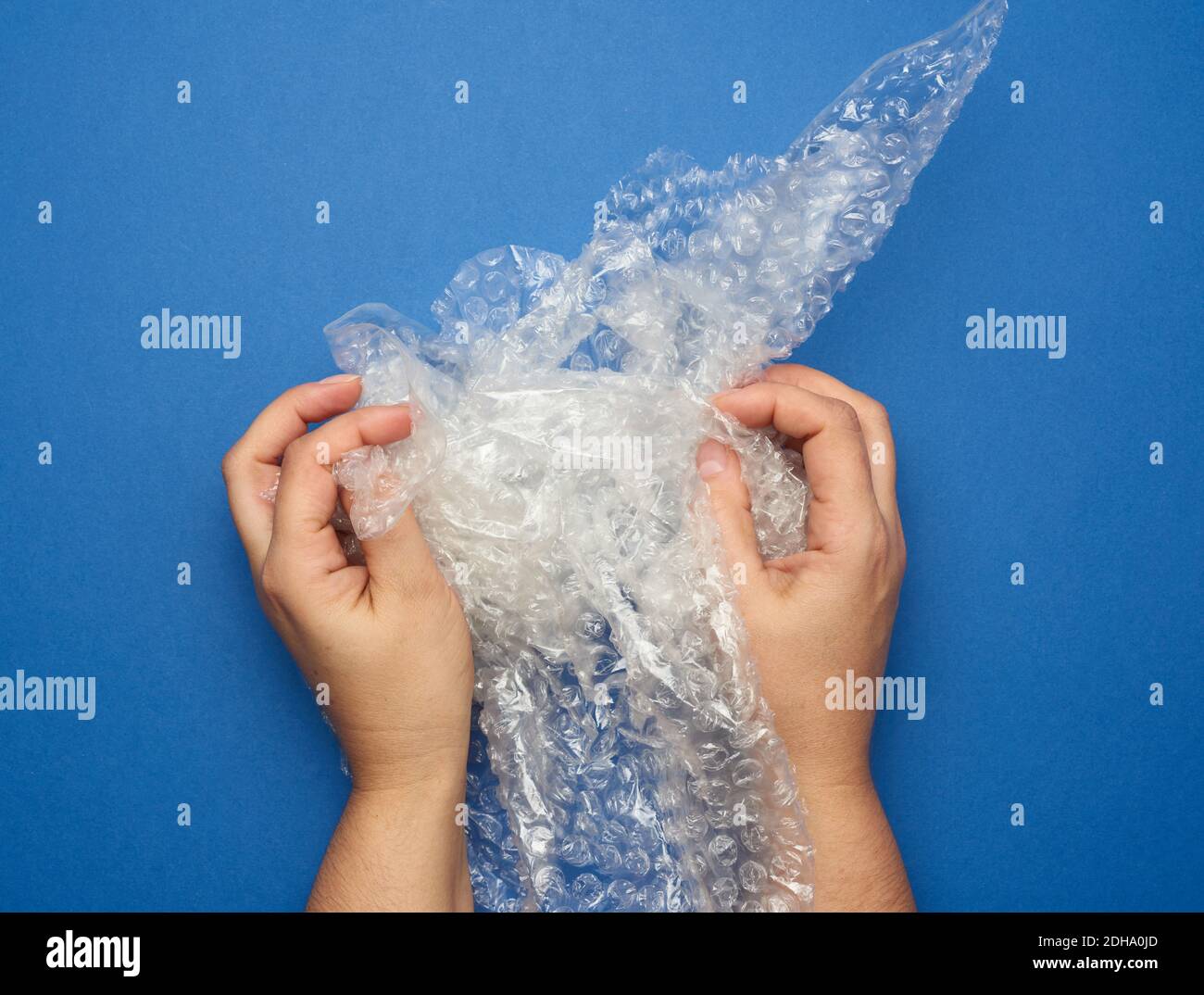 Female hand holding crumpled piece of polyethylene with air bubbles Stock Photo