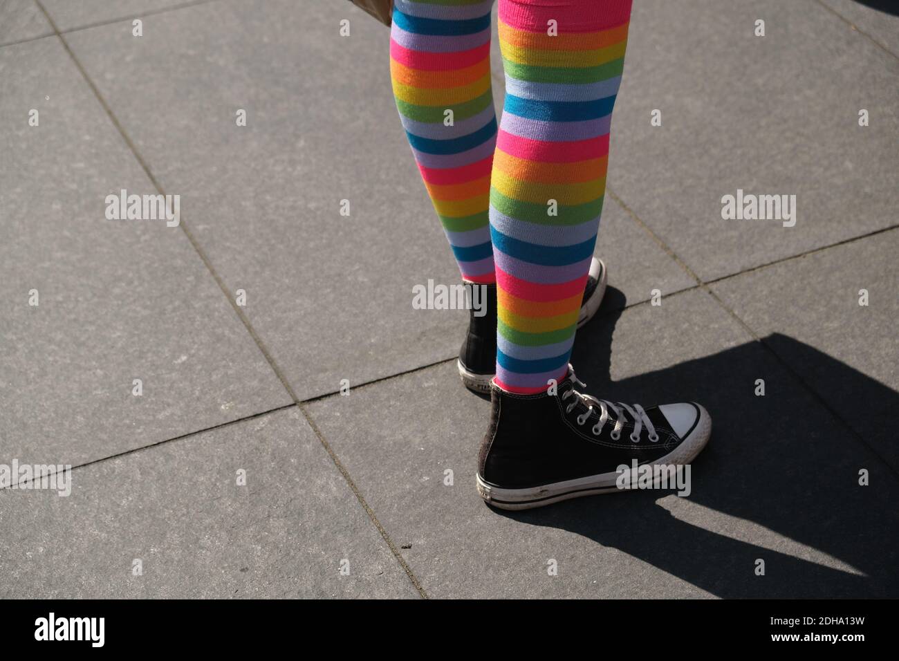 A closeup of female legs wearing rainbow socks and sneakers Stock Photo -  Alamy