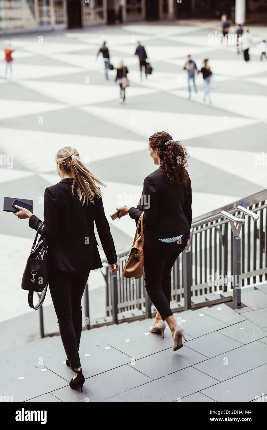 Businesswomen moving down staircase Stock Photo