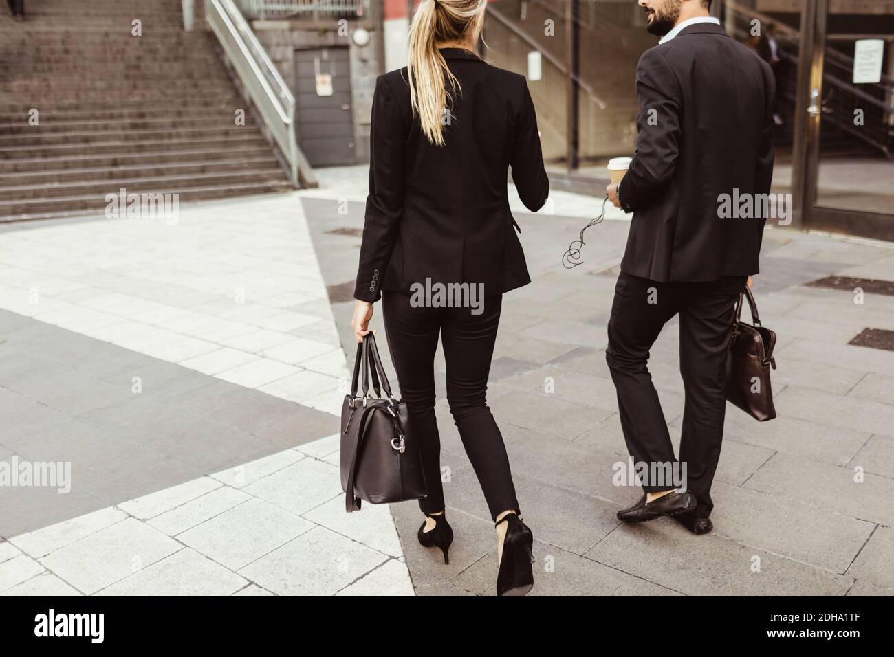 Rear view of business people walking and talking outdoors Stock Photo ...