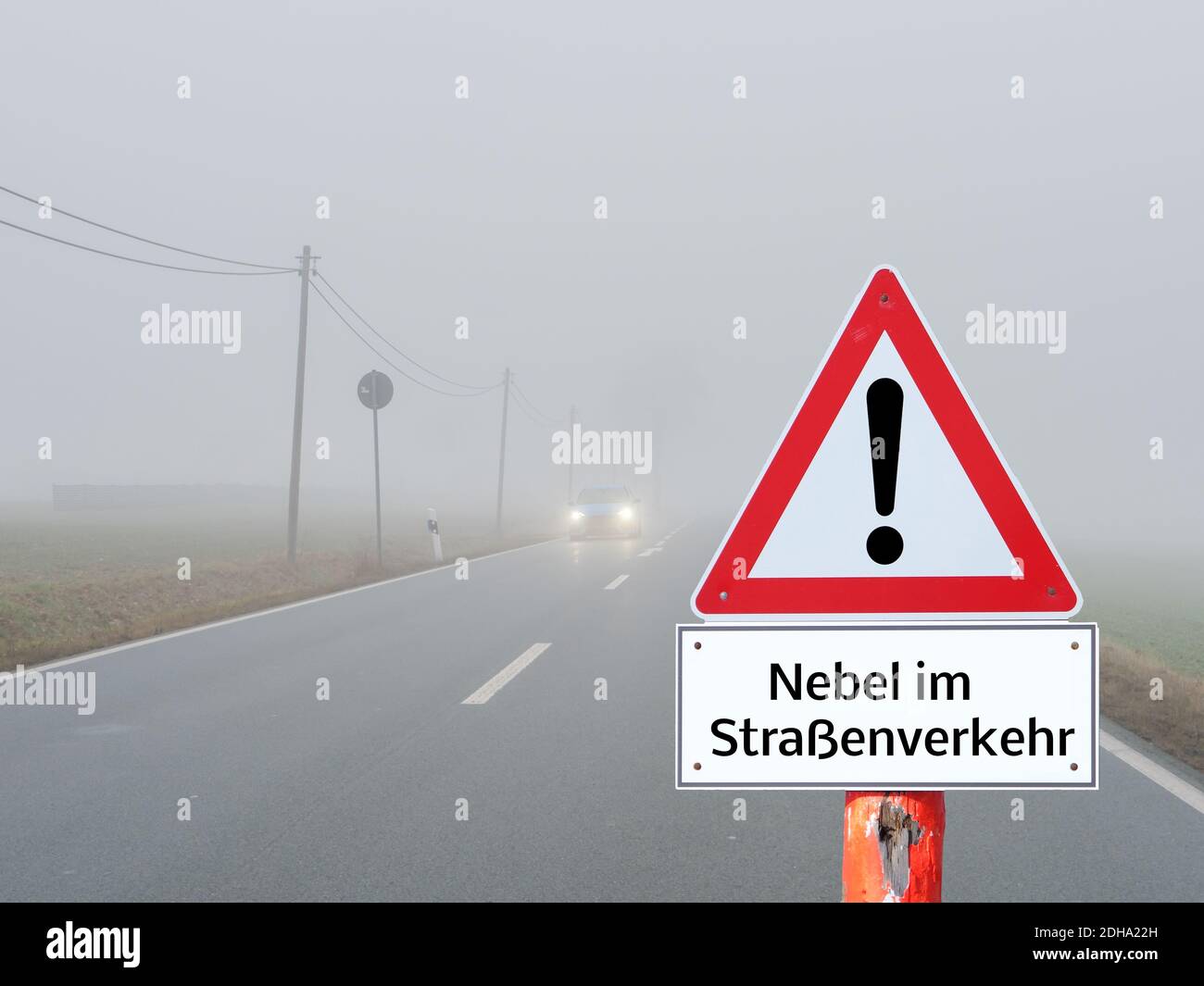 Fog warning sign in road traffic in a curve in german Stock Photo