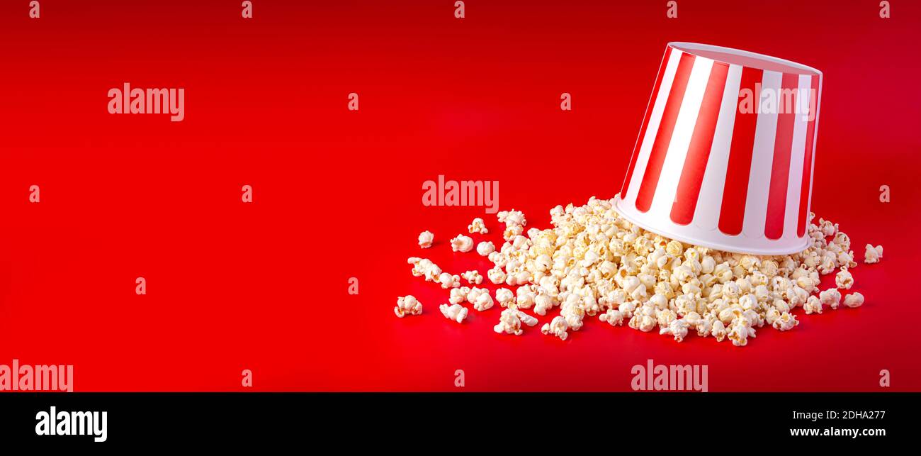 Striped box with popcorn on red background Stock Photo
