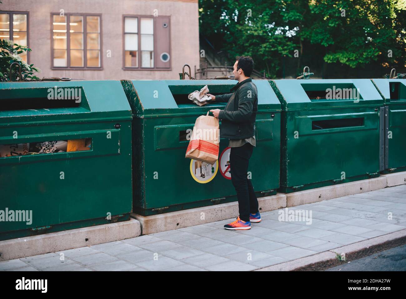 Full length of man throwing garbage in can Stock Photo Alamy