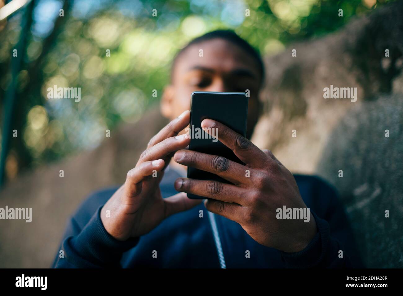 Low angle view of young man using smart phone Stock Photo