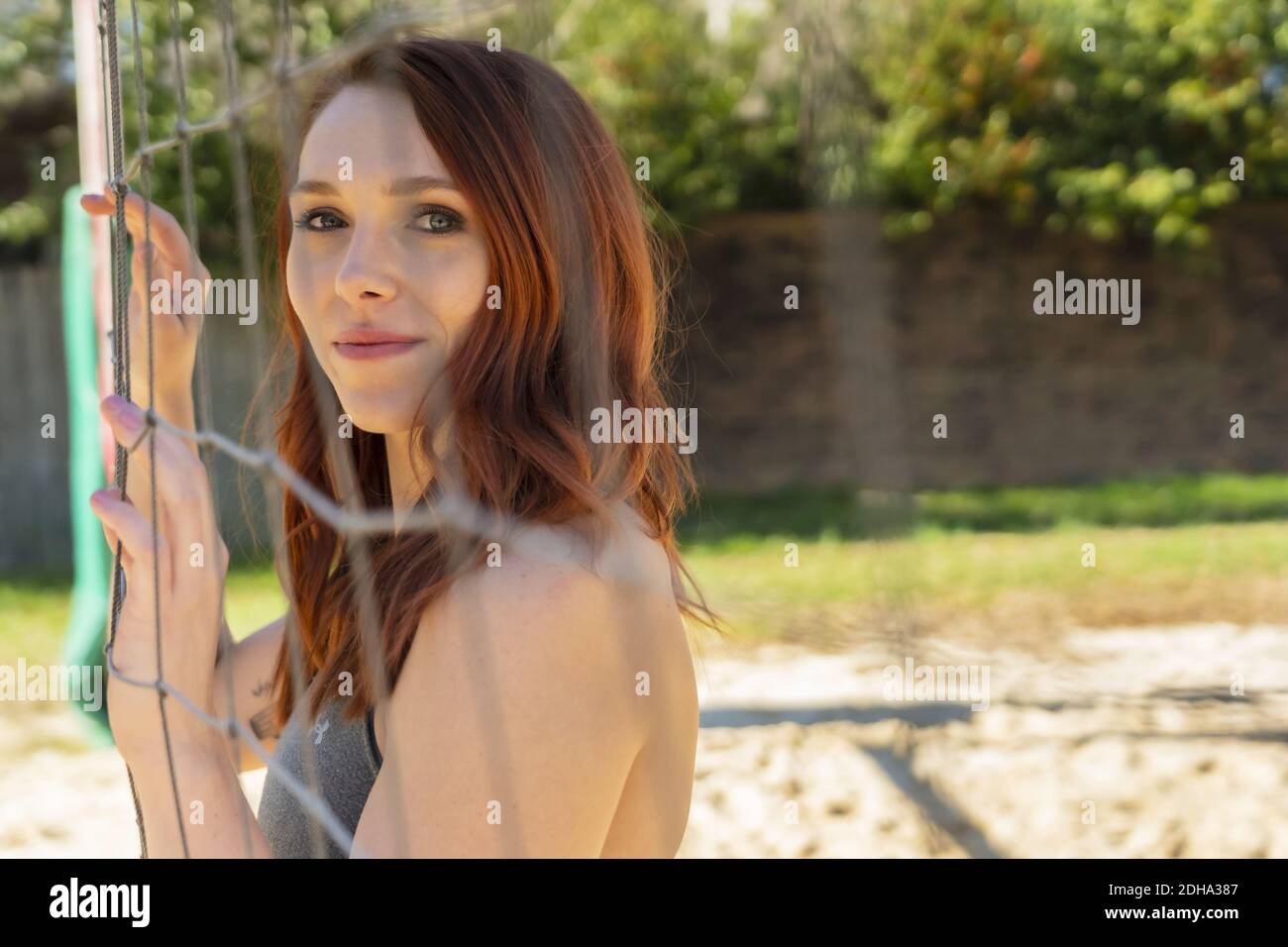 A Gorgeous Redhead Fitness Model Preparing To Play Volleyball Stock Photo