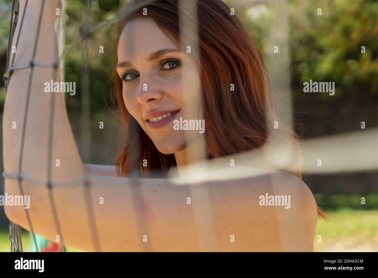 A Gorgeous Redhead Fitness Model Preparing To Play Volleyball Stock Photo