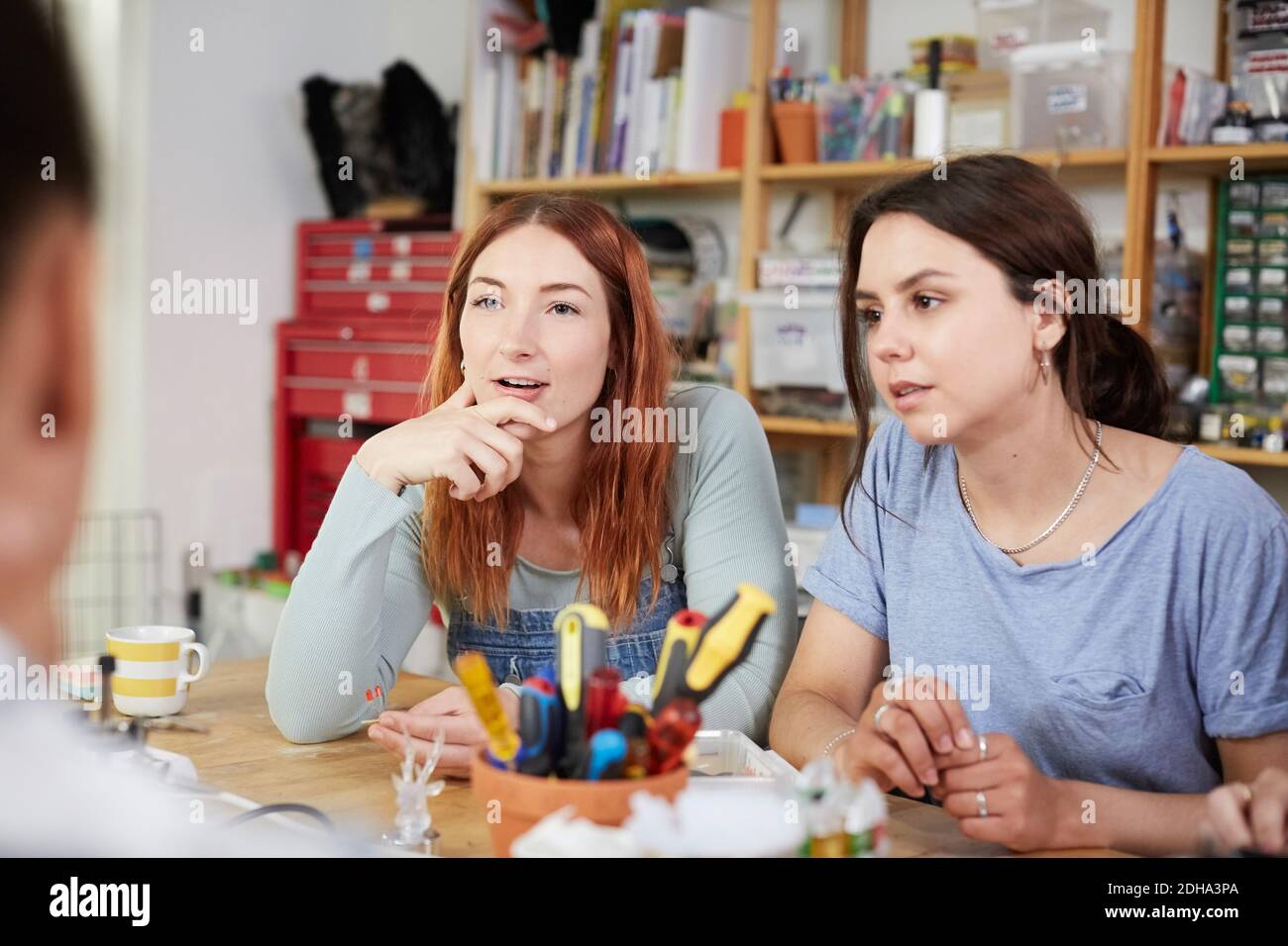Female technicians sitting at table in workshop Stock Photo
