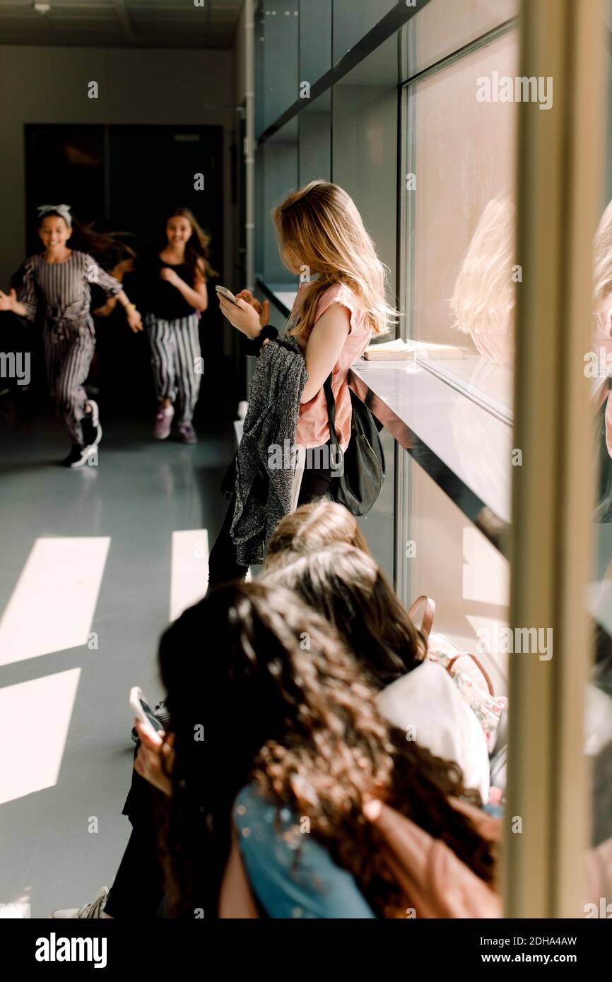 Female students in school corridor during lunch break Stock Photo