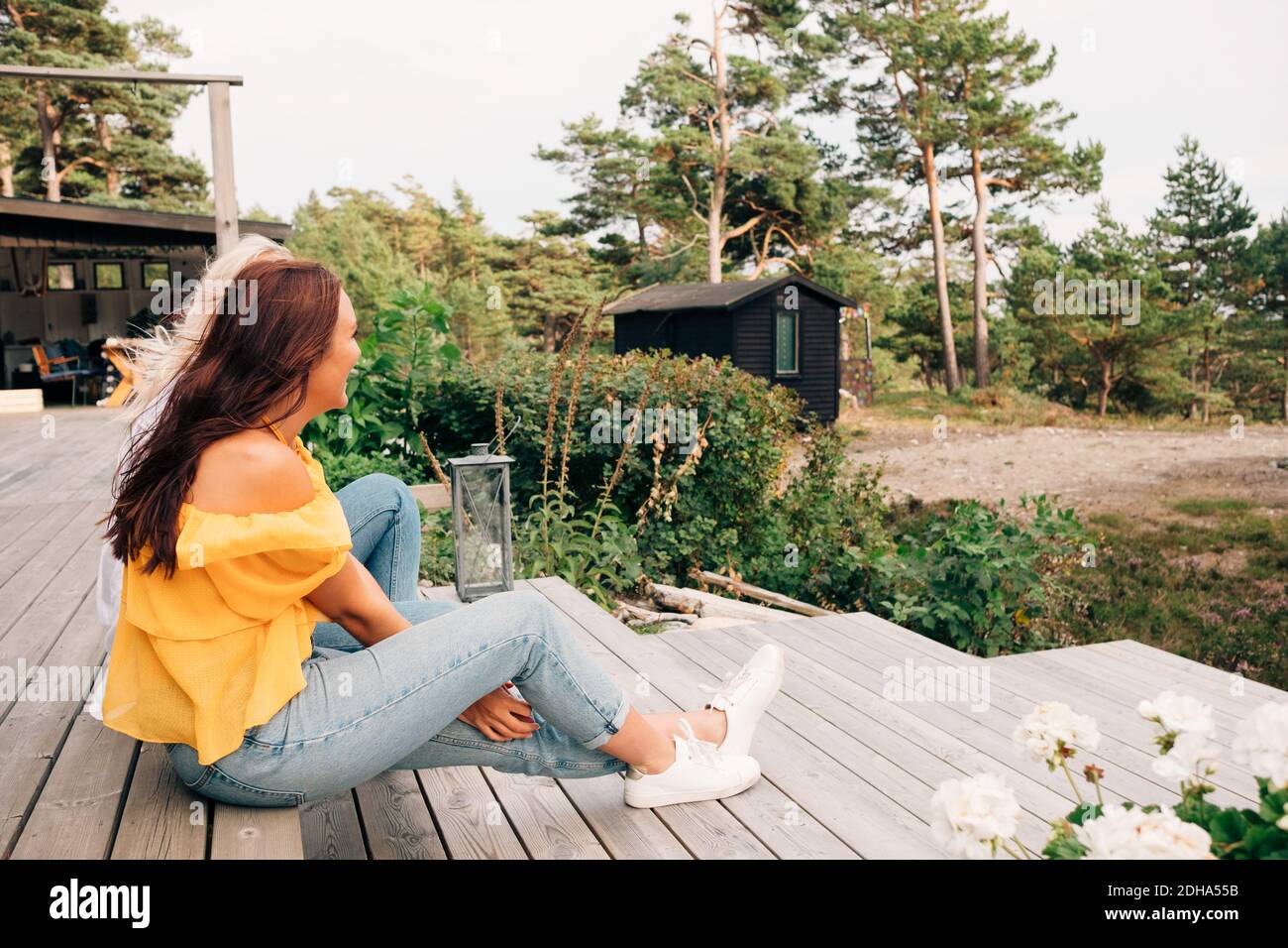 Happy young women sitting on cottage deck Stock Photo