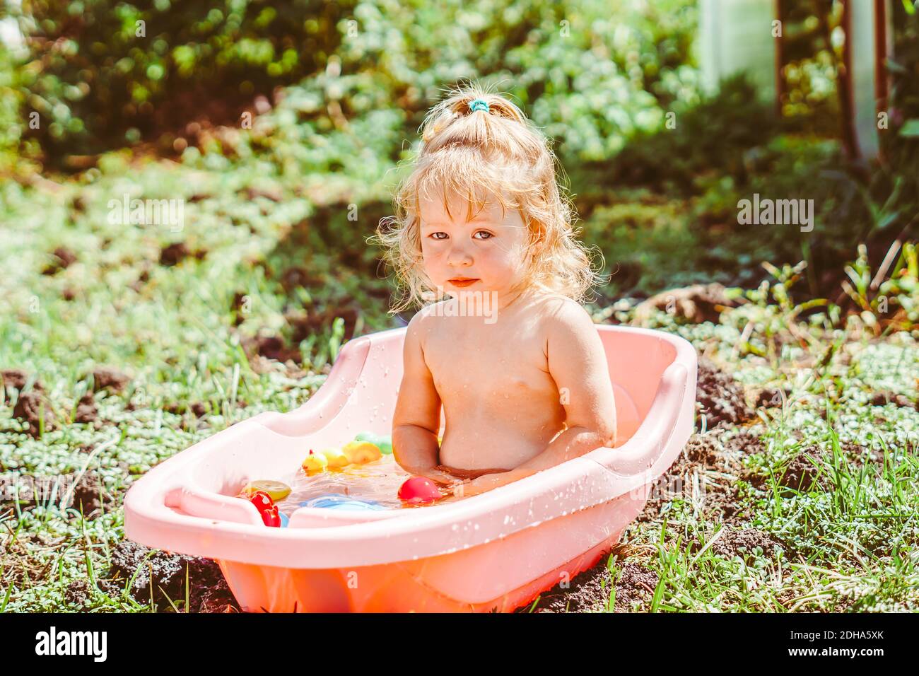 happy baby taking a bath outdoors in the garden Stock Photo Alamy