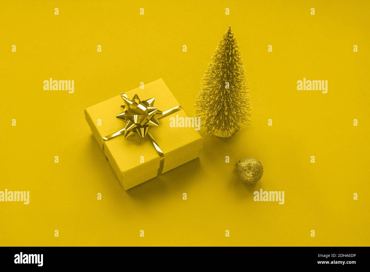 New Year's gift, Christmas tree toy and bauble on yellow background, toned in trendy 2021 color. Top view. Stock Photo