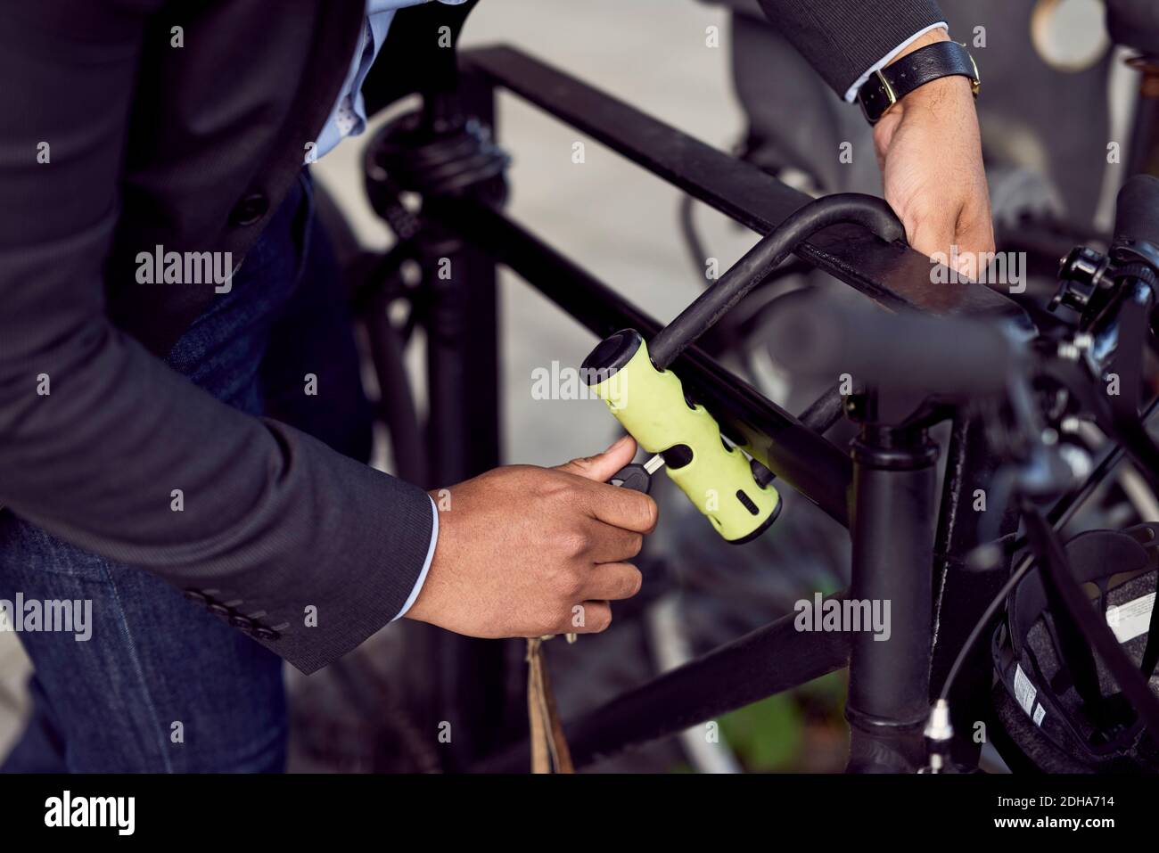 Midsection of man locking bicycle in city Stock Photo