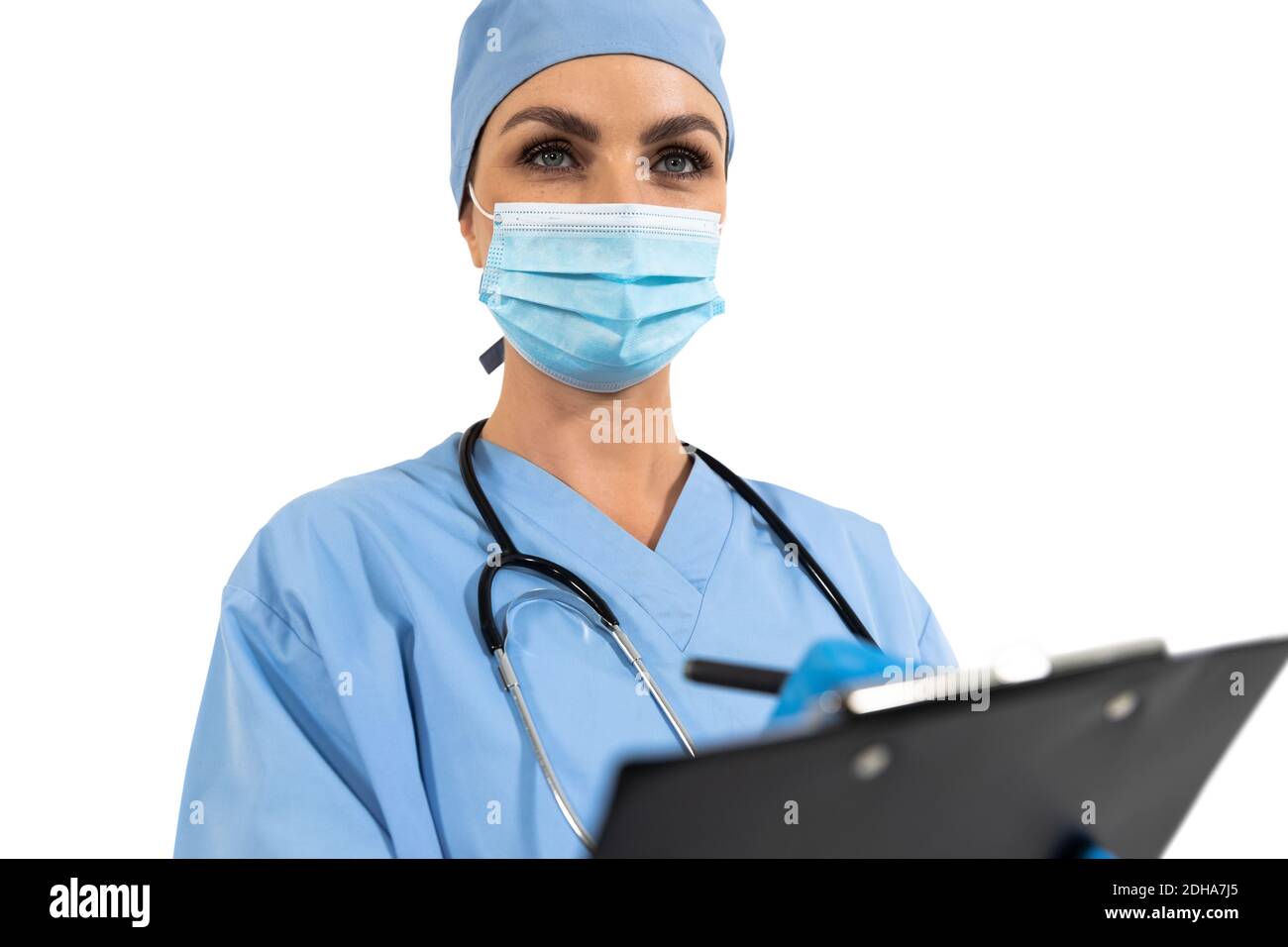 Female surgeon wearing face mask using clipboard against white background Stock Photo