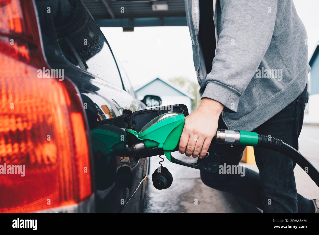 Midsection of man refueling car at gas station Stock Photo