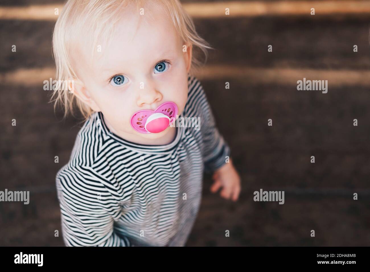 High angle view of girl with pacifier standing outdoors Stock Photo