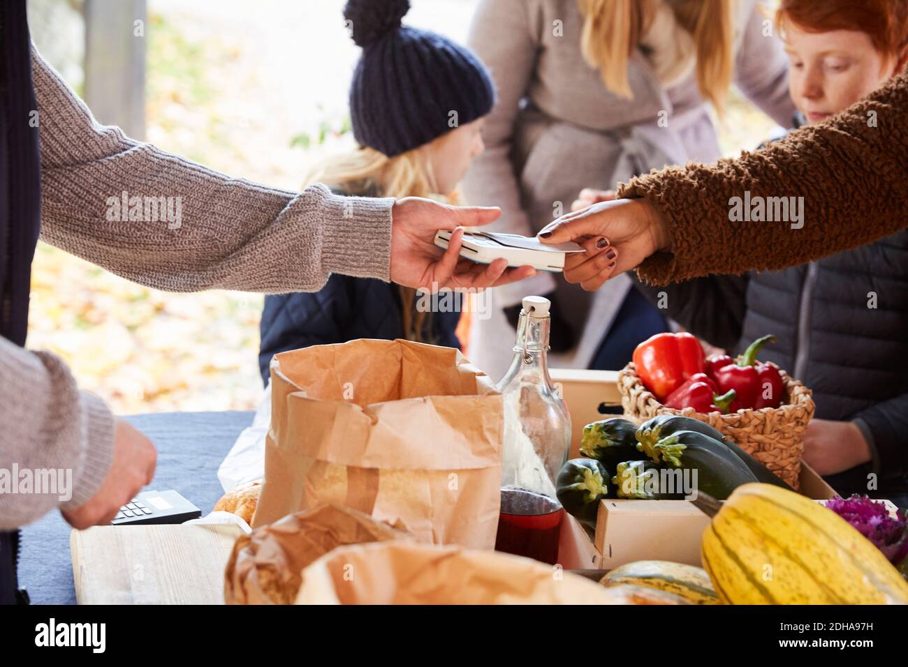 Woman paying through credit card to male vendor at market stall Stock Photo