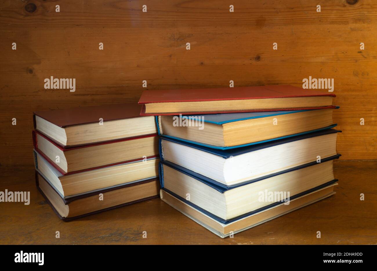 The Stack of the books rests upon wooden regiment. Subjects in closet close-up Stock Photo