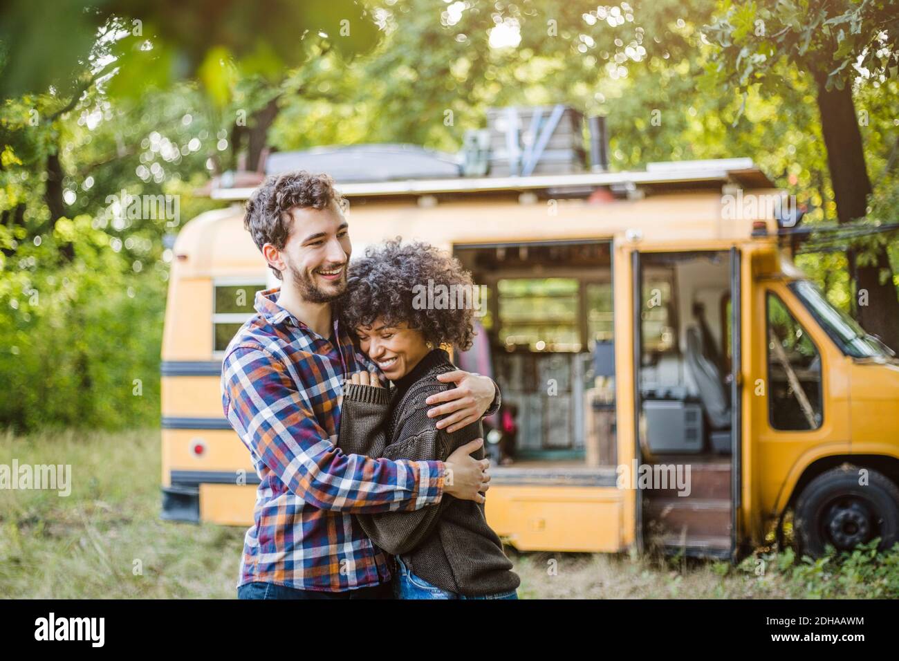 Happy young couple embracing while enjoying camping in forest Stock ...