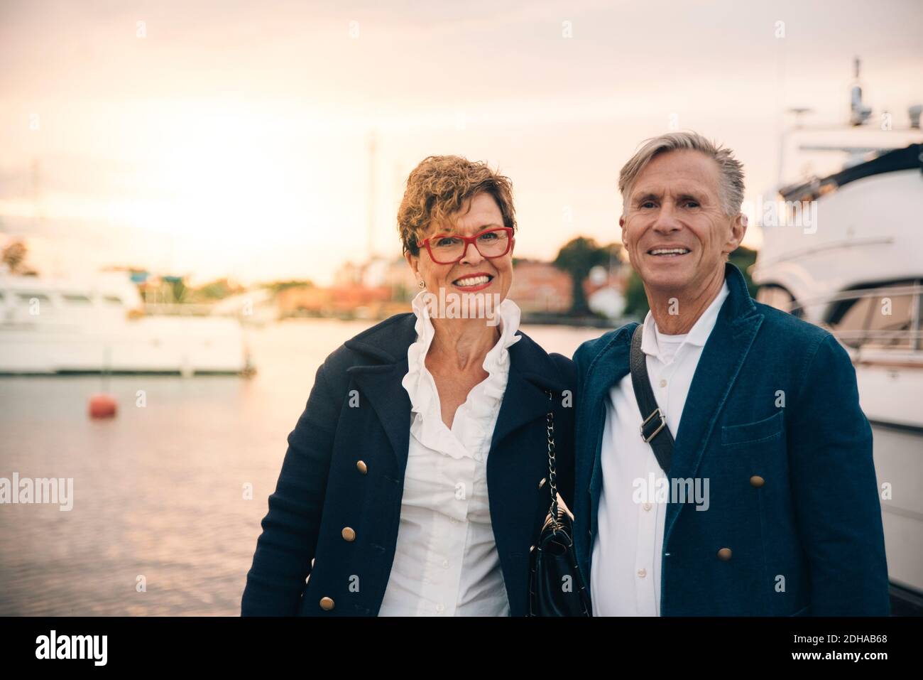 Portrait of confident senior couple smiling at harbor Stock Photo