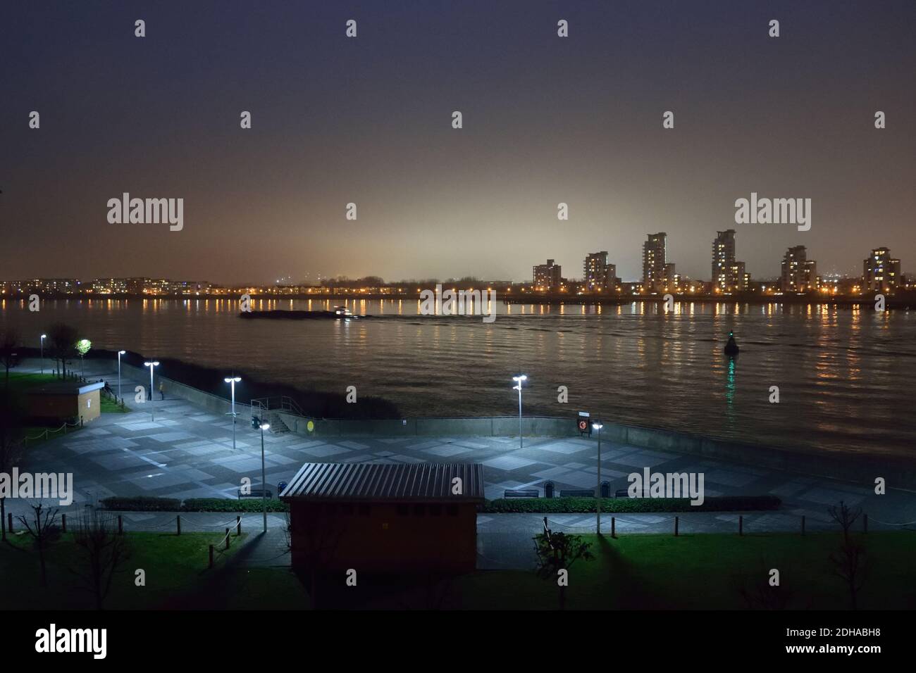 Nigh time view across River Thames in London with a bank of fog behind tall apartment buildings Stock Photo