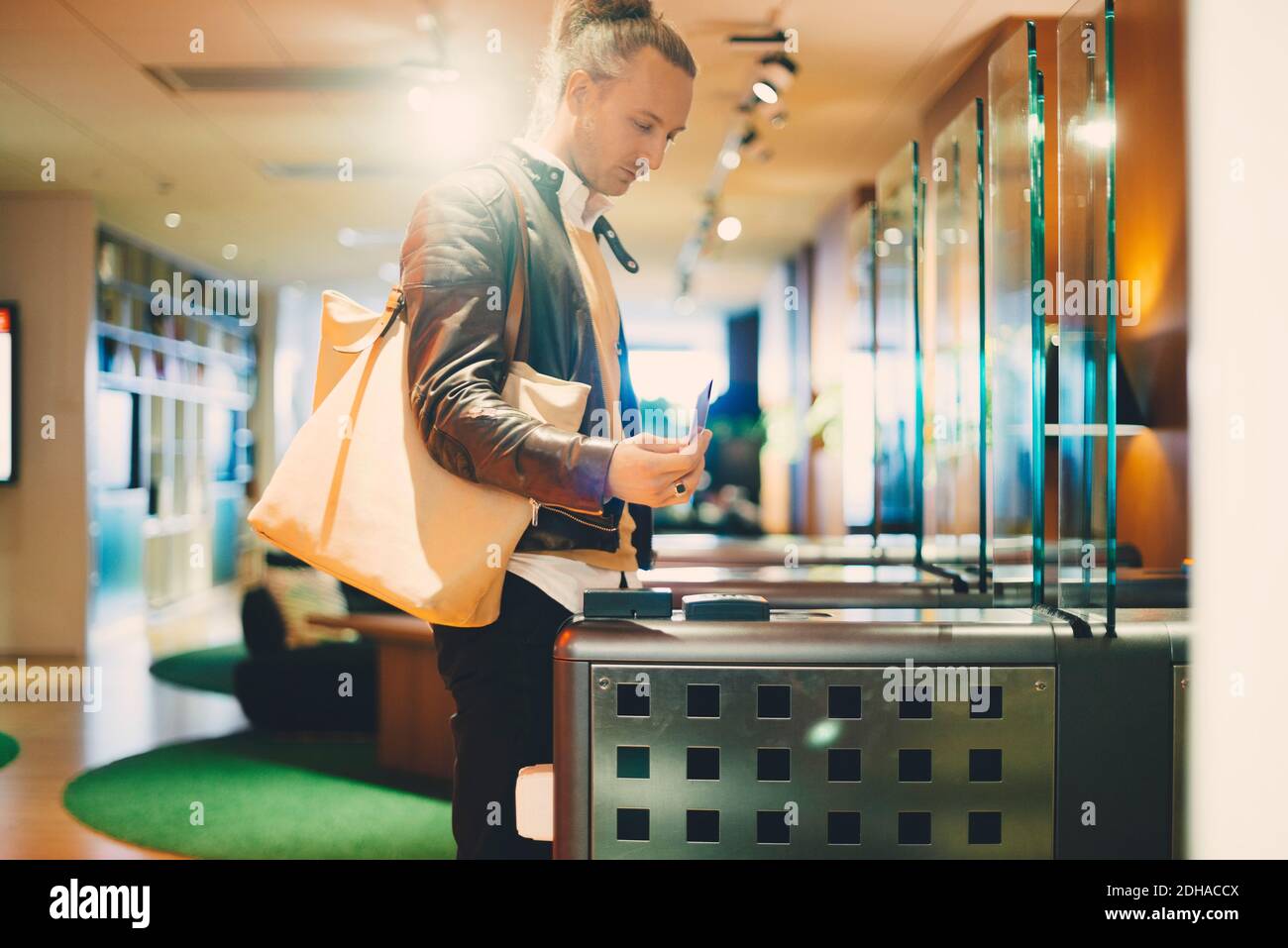 Businessman using ID card at turnstile in office Stock Photo