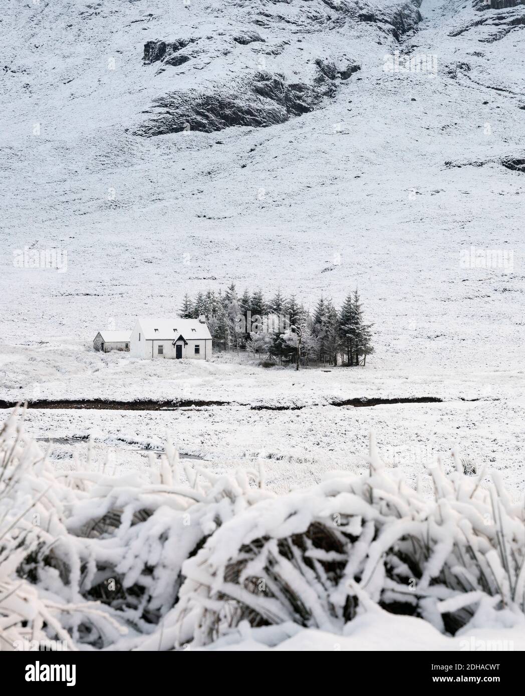 Snow covered winter landscape and cottage in Glen Coe in Scottish Highlands, Scotland, UK Stock Photo