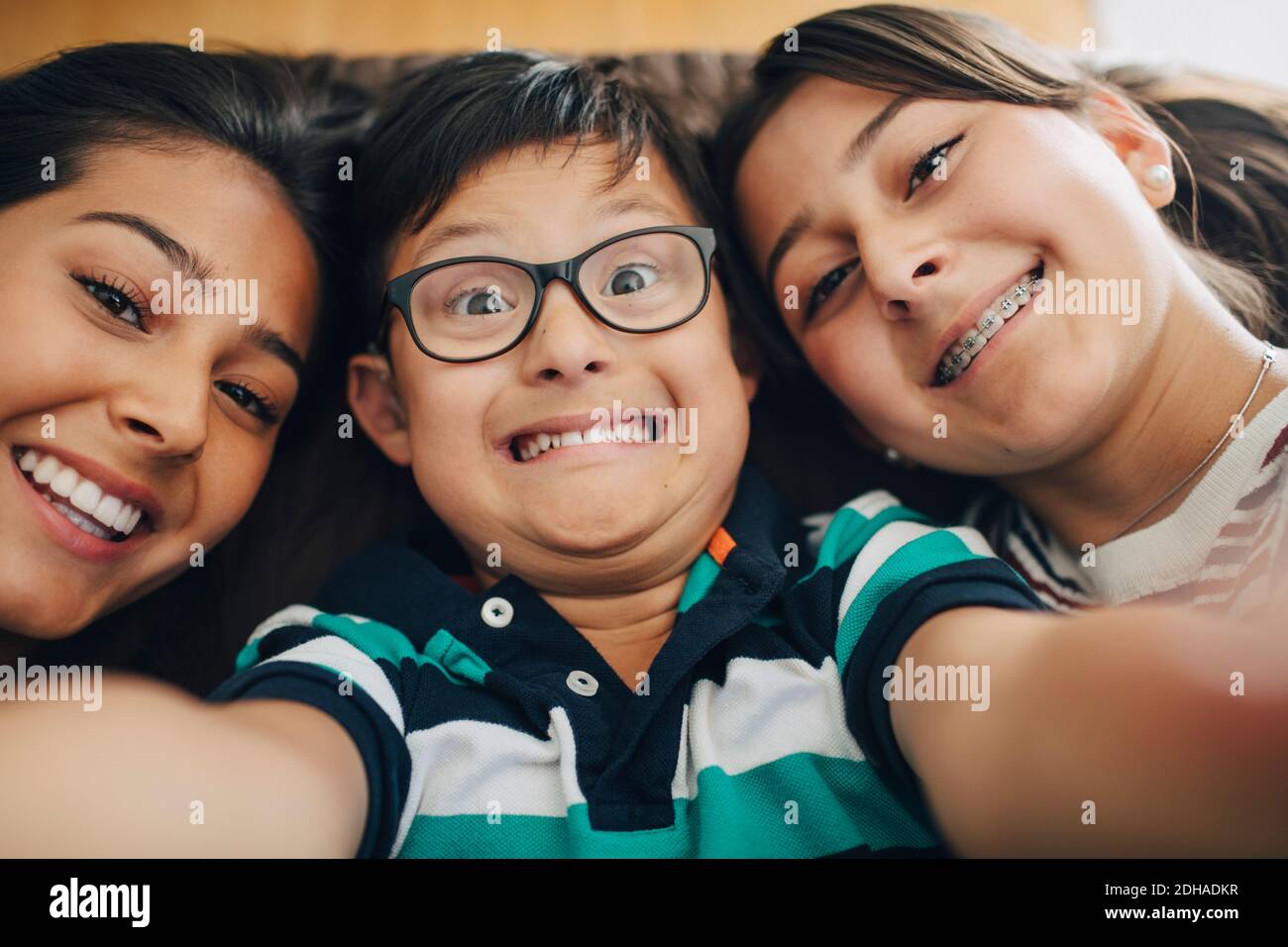 High angle portrait of smiling siblings lying on bed at home Stock Photo
