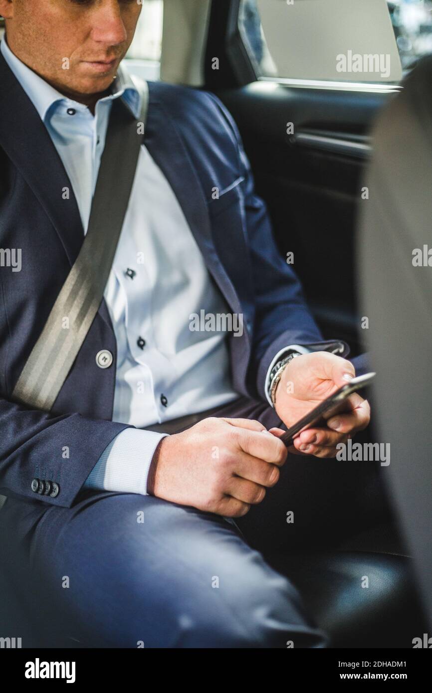 Mature businessman using mobile phone while sitting in car Stock Photo