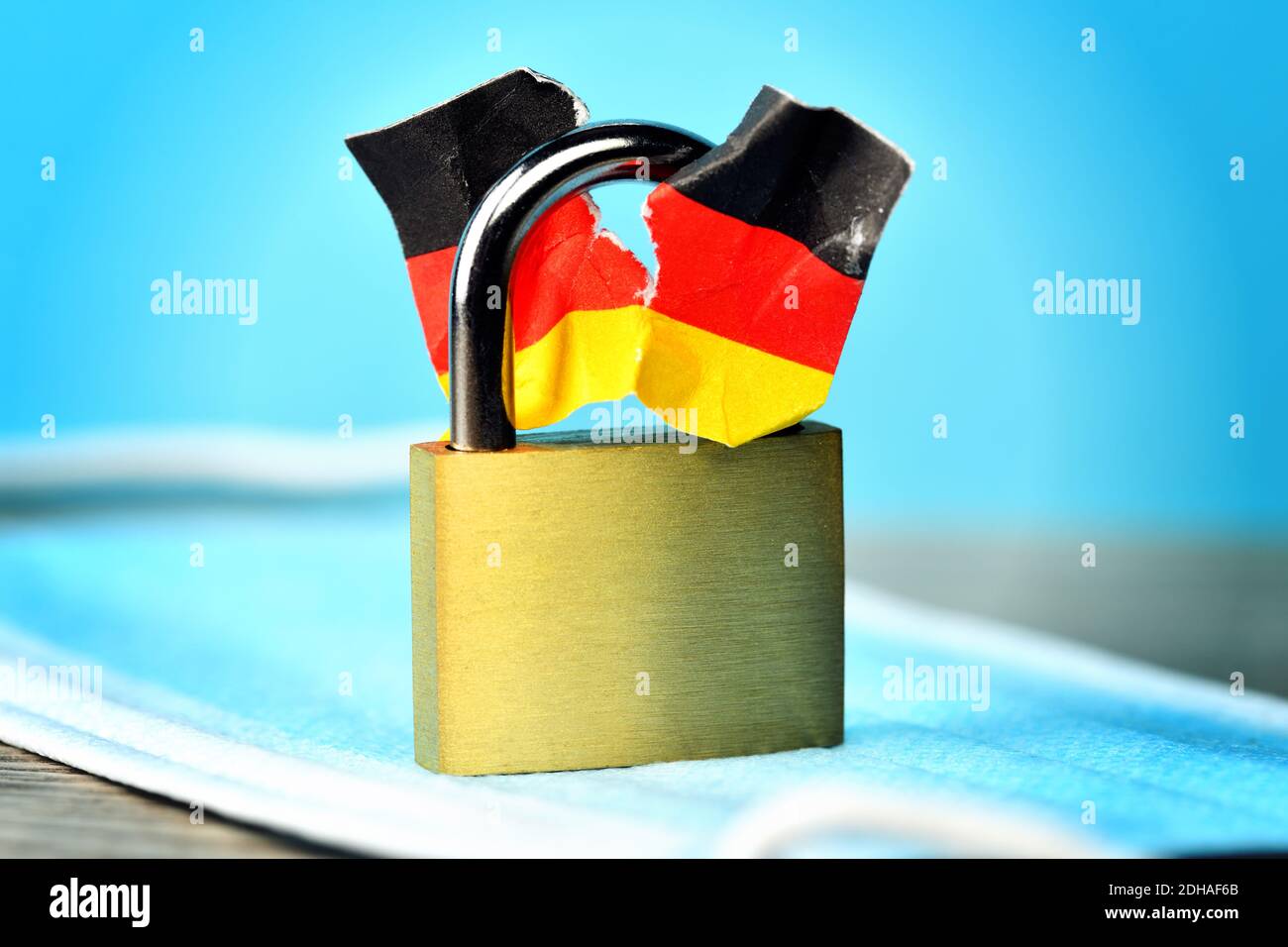 Geschlossenes Vorhängeschloss mit angerissener Deutschlandfahne, Spaltung der Gesellschaft durch den Lockdown Stock Photo