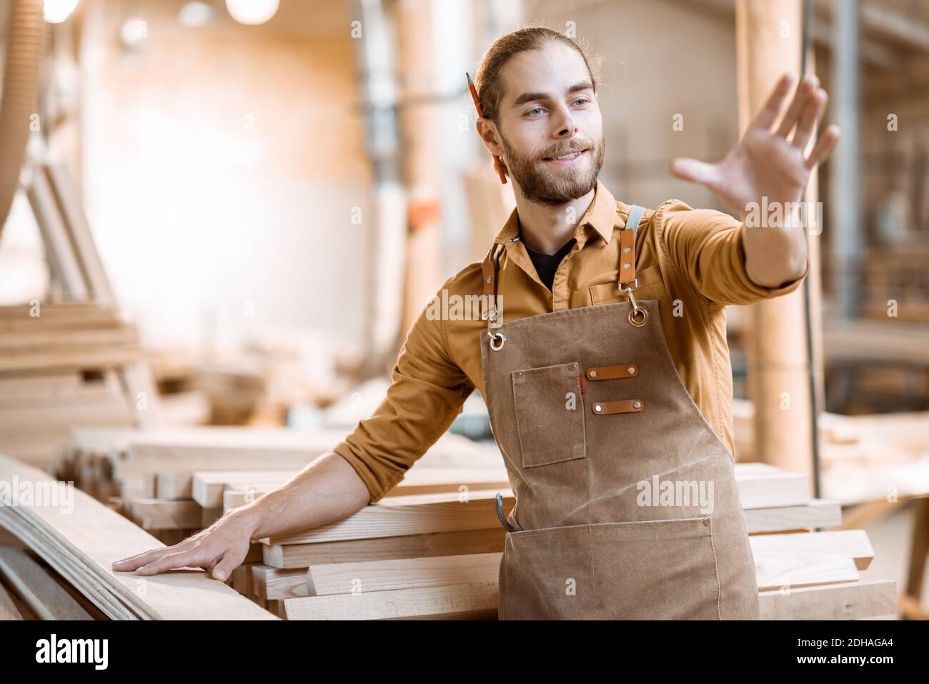 Handsome carpenter designing some woodwork at the workshop. Concept of augmented reality in carpentry Stock Photo
