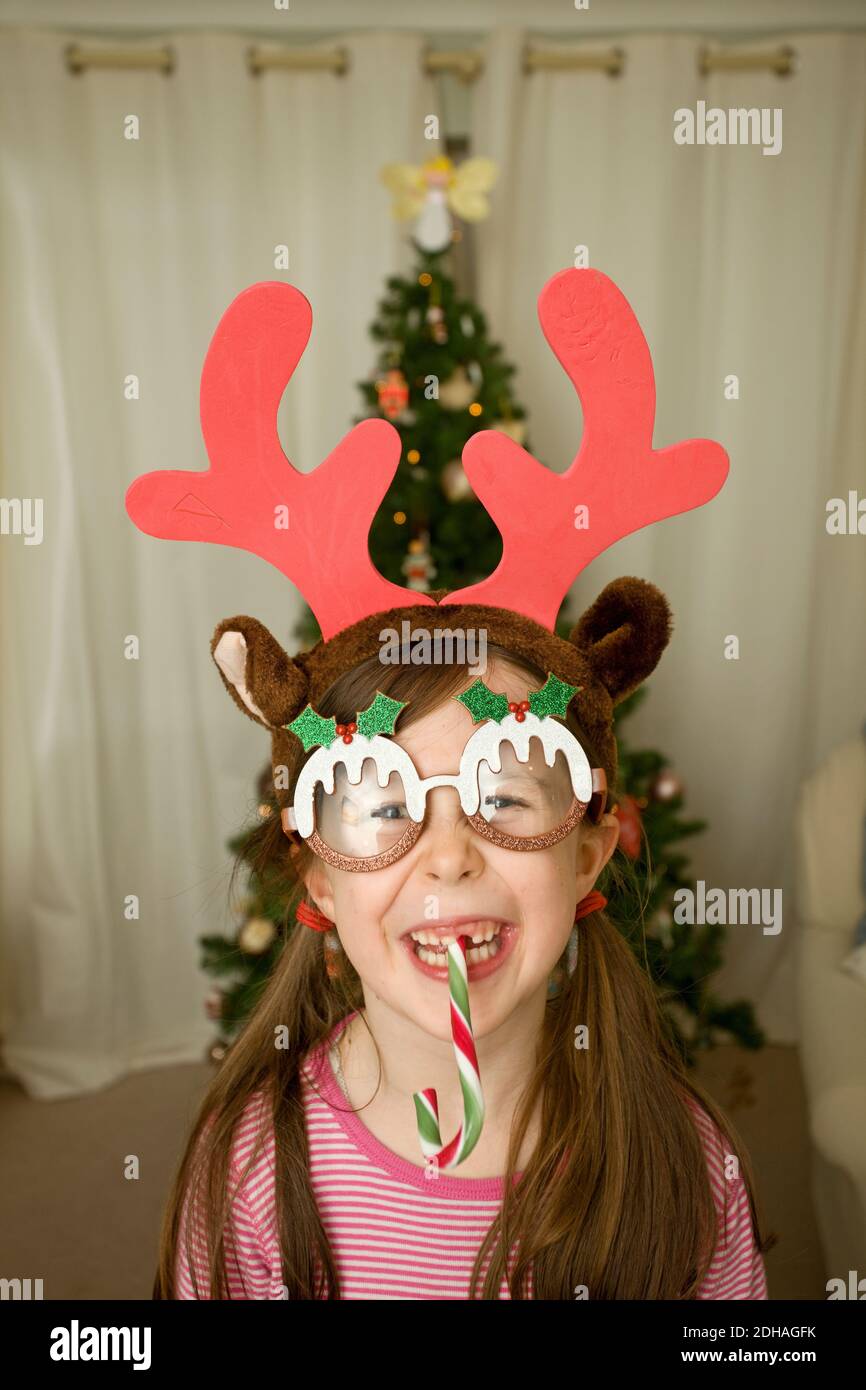 Young girl wearing funny Christmas glasses and antlers Stock Photo