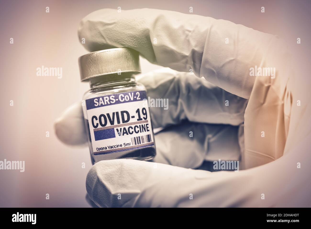 Hand im Latexhandschuh hält Injektionsfläschchen mit Corona-Impfstoff, Symbolfoto Corona-Impfmittel Stock Photo