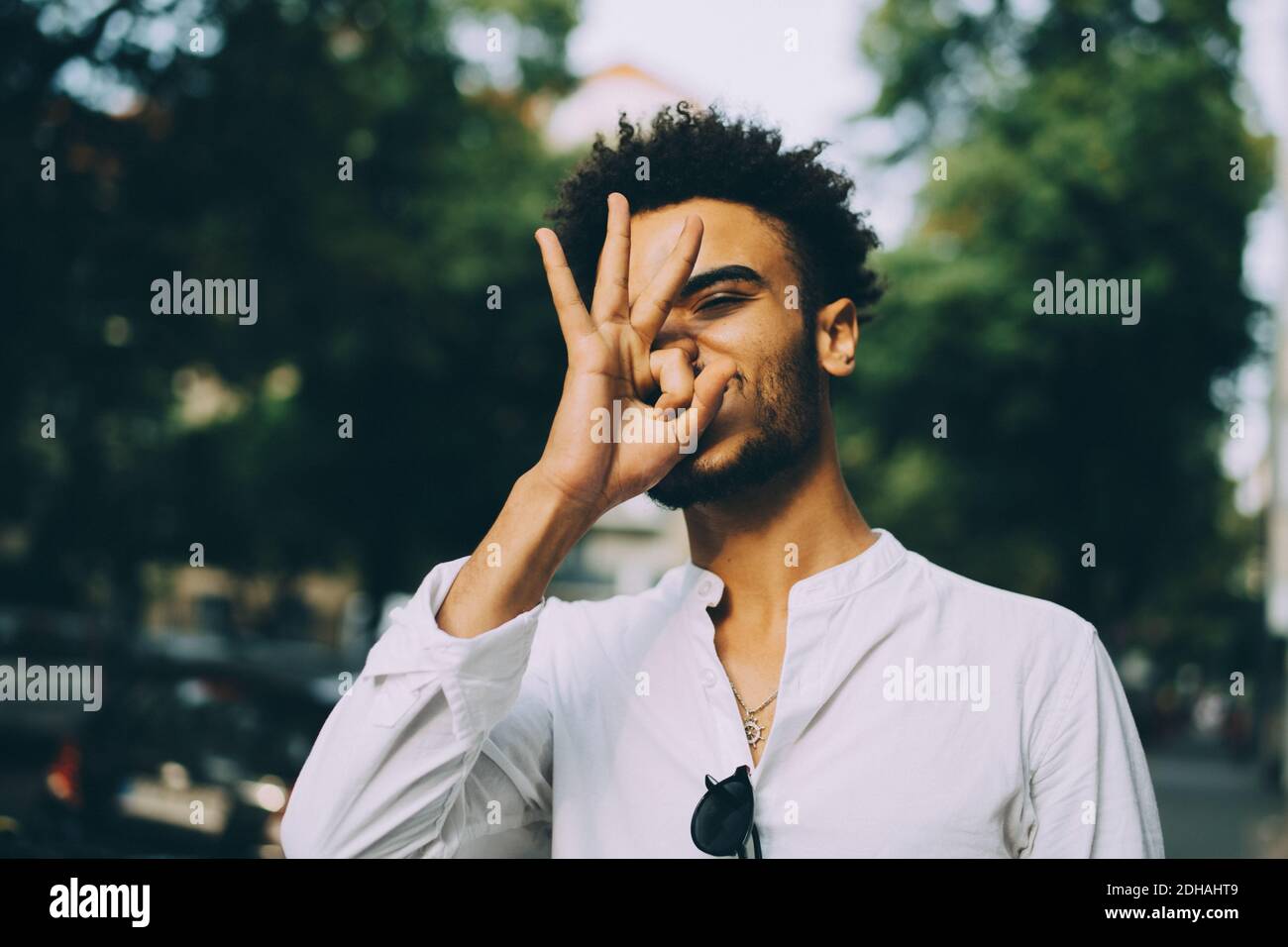 Young man gesturing while standing in city Stock Photo