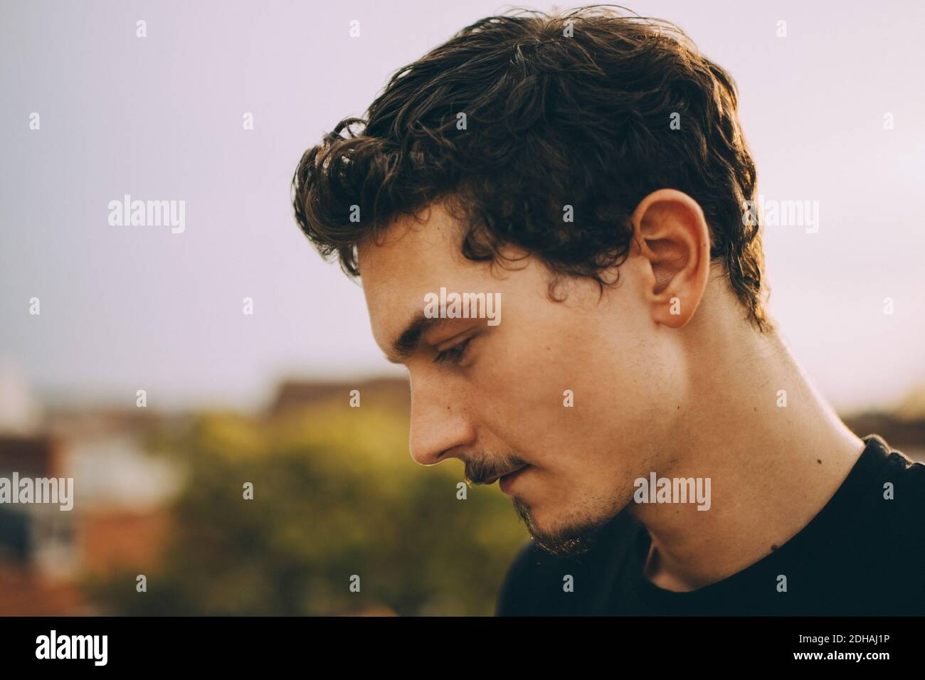Close-up of thoughtful young man looking down at terrace Stock Photo