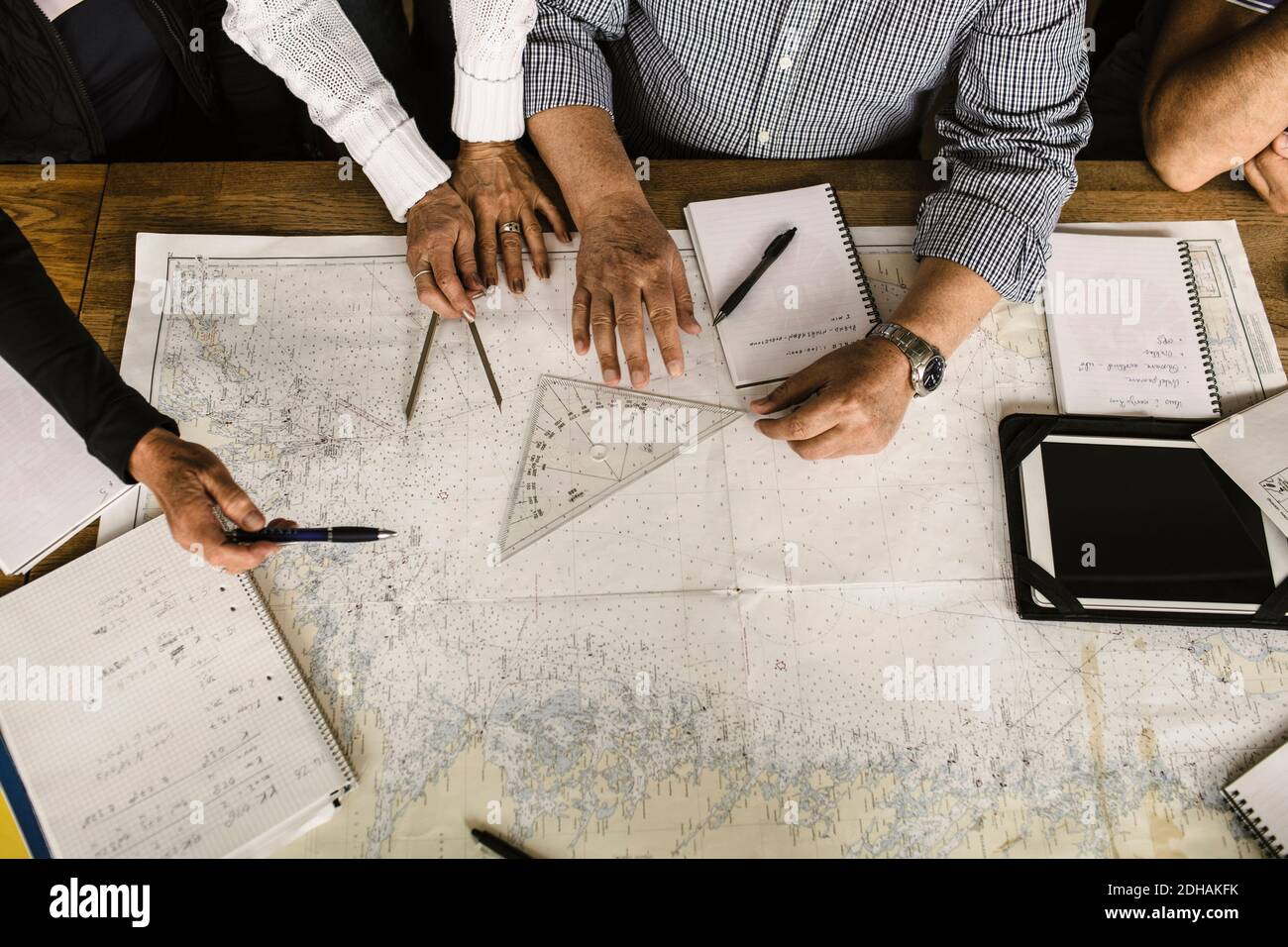 High angle view of senior men and women with map at table during navigation course Stock Photo