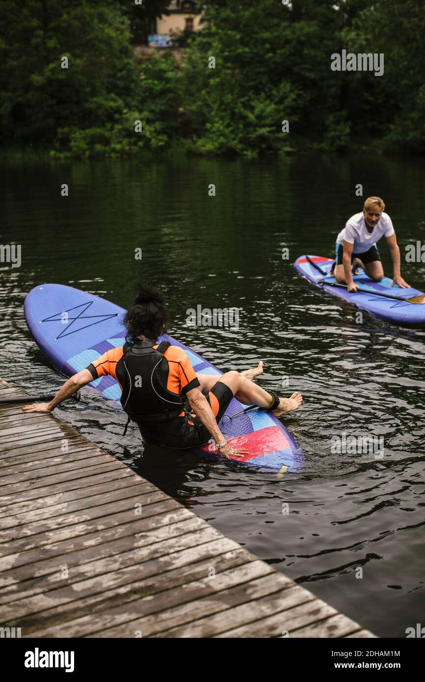 Senior woman learning paddleboarding in sea during SUP course Stock Photo