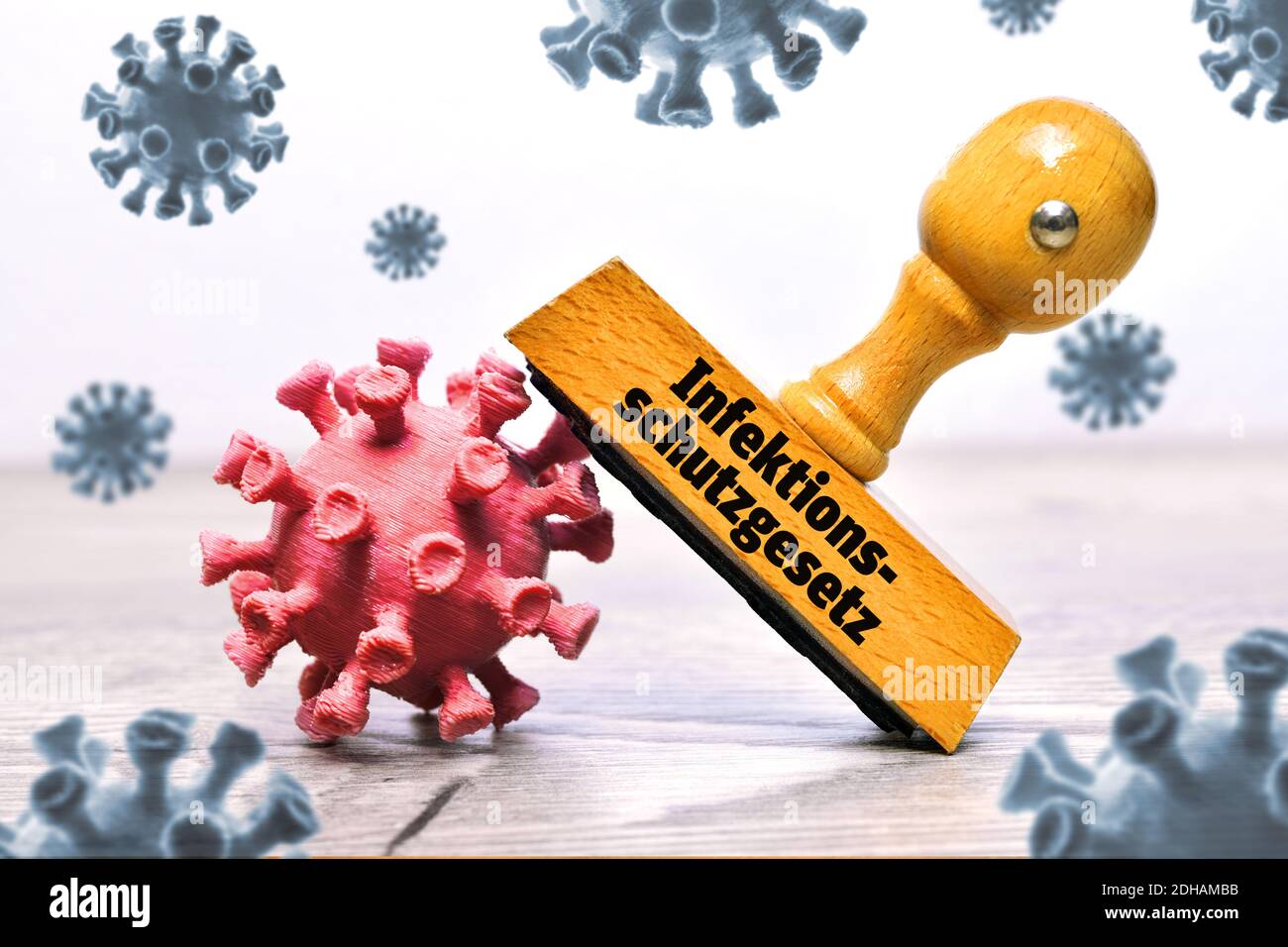 FOTOMONTAGE, Coronaviren und Stempel mit der Aufschrift Infektionsschutzgesetz Stock Photo