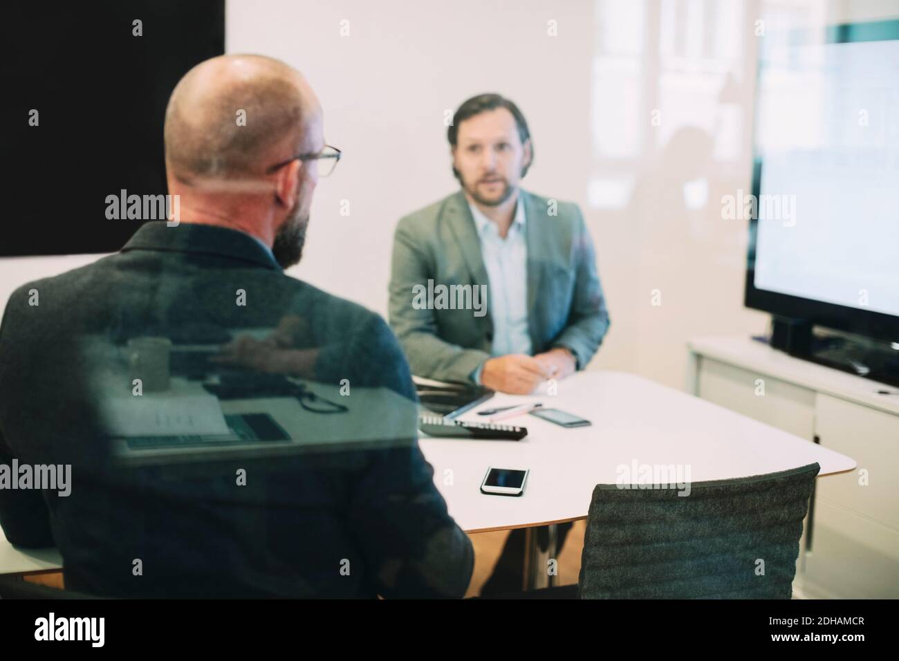 Business colleagues discussing in meeting seen through glass at office Stock Photo