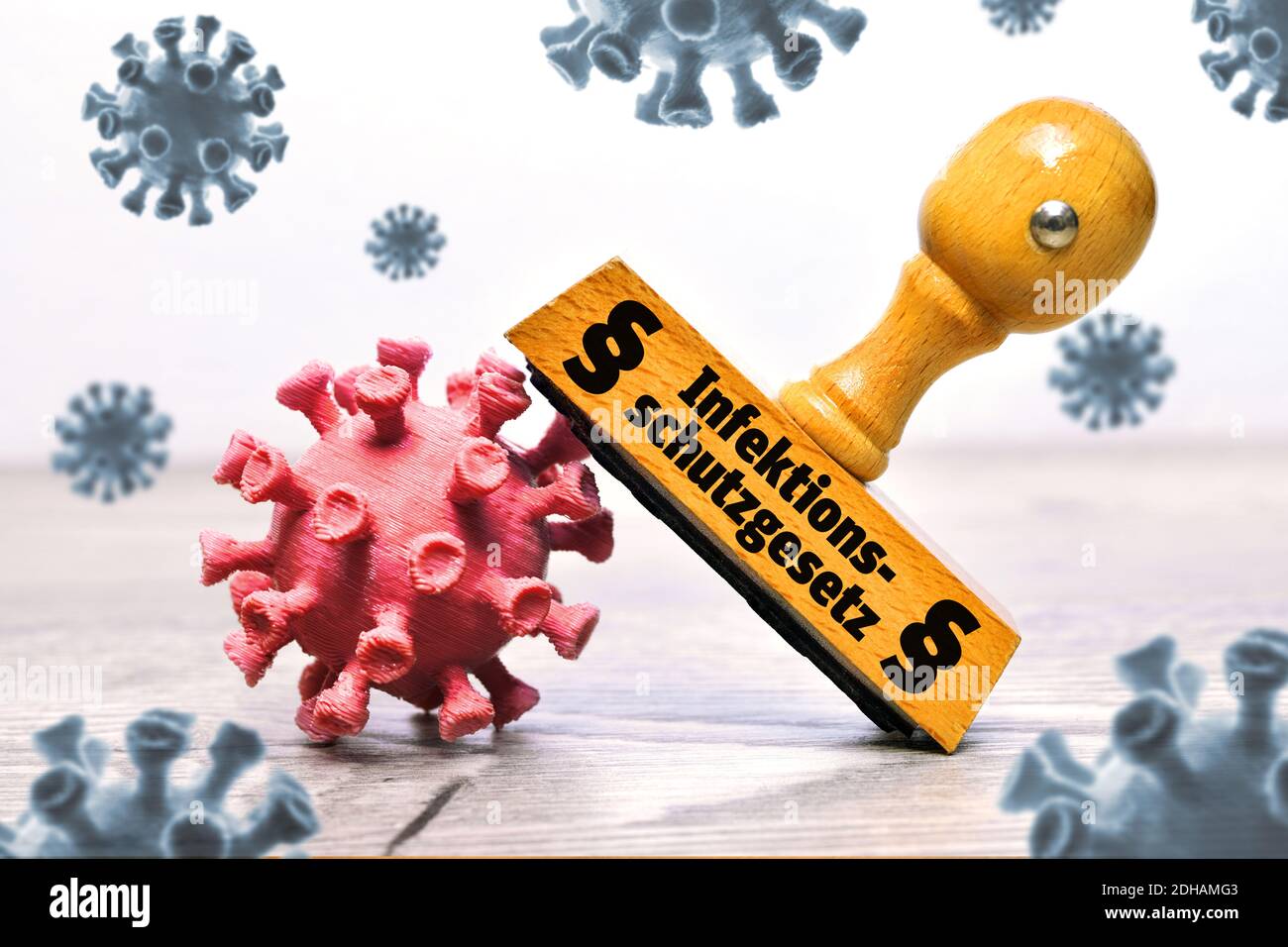 FOTOMONTAGE, Coronaviren und Stempel mit der Aufschrift Infektionsschutzgesetz und Paragrafenzeichen Stock Photo