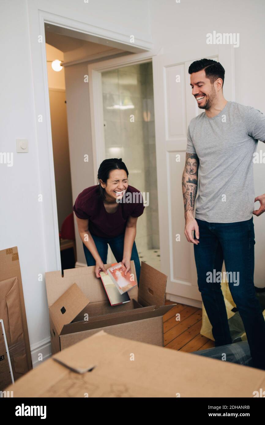 Couple enjoying while unpacking boxes in new apartment Stock Photo