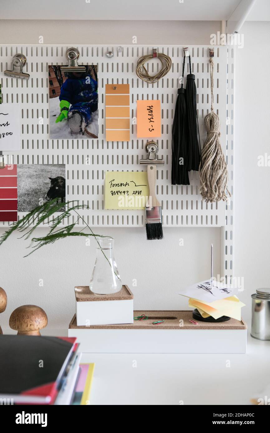 Various objects hanging on pegboard at home office Stock Photo