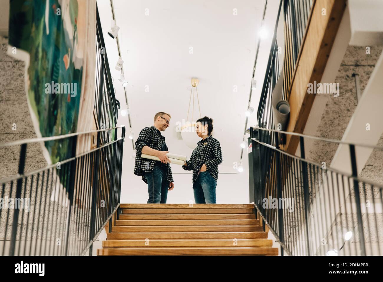 Low angle view of coworkers standing on top of staircase in store Stock Photo
