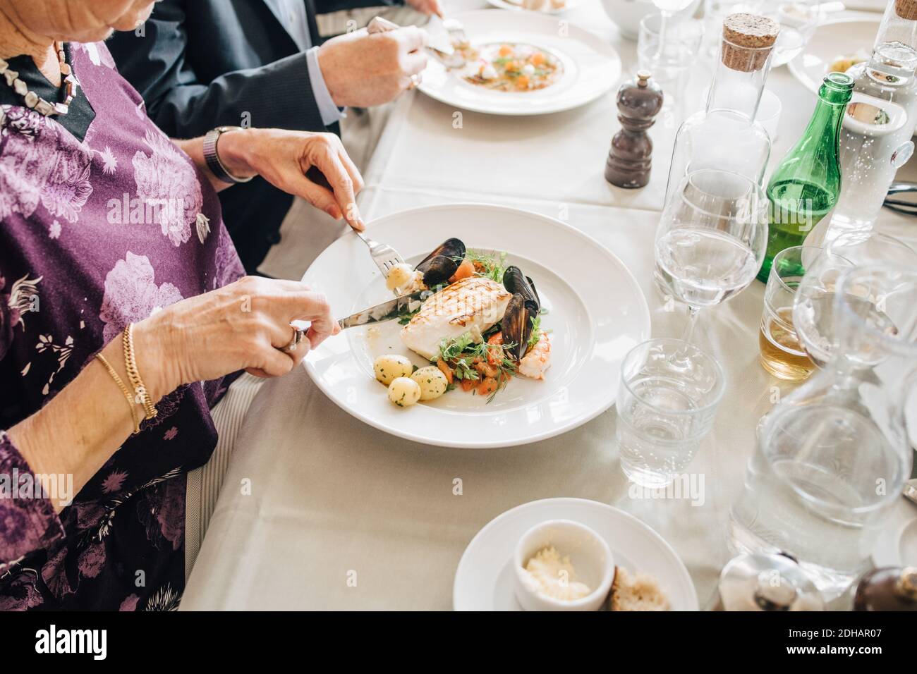 Midsection of senior friends with food in restaurant Stock Photo