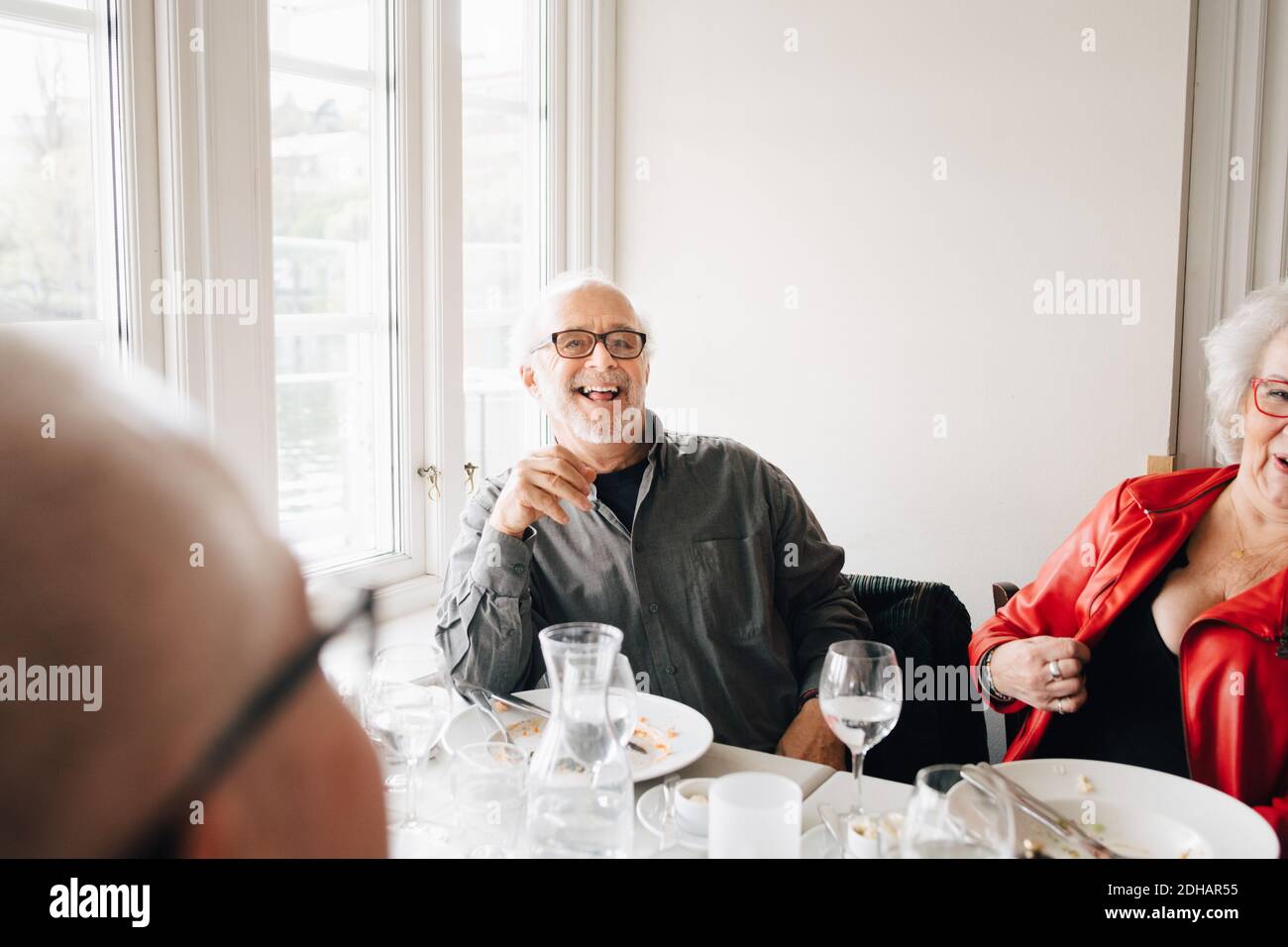Happy Senior friends enjoying while sitting in restaurant Stock Photo