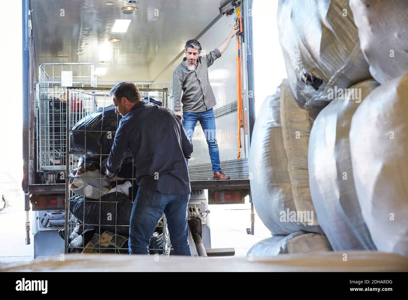 Mature coworkers unloading semi-truck at warehouse Stock Photo
