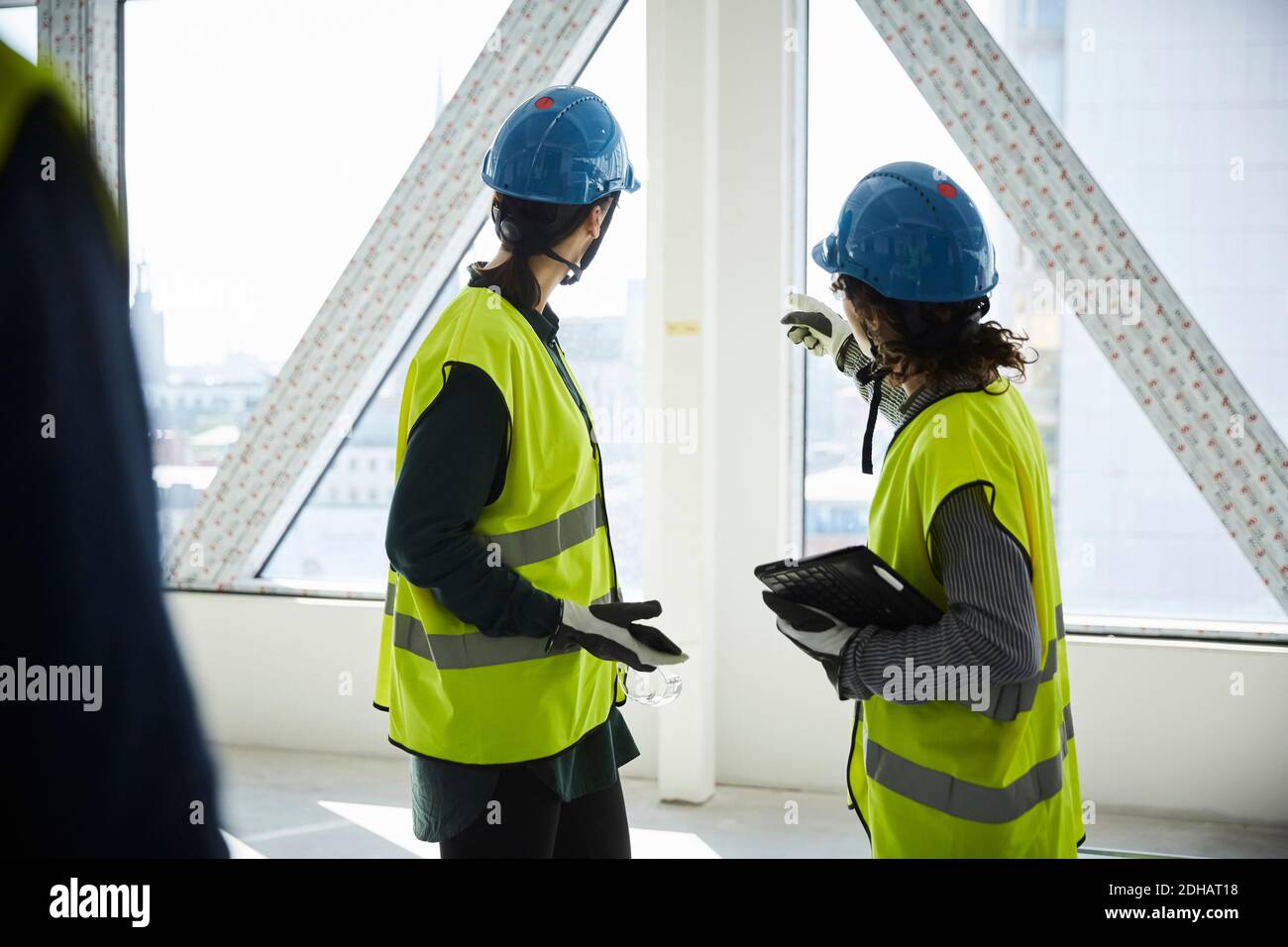 Side view of female engineers discussing at construction site Stock Photo